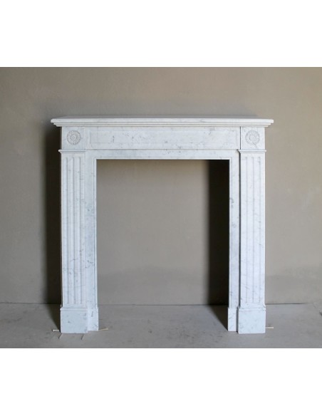 Neoclassical-style fireplace mantel carved in white Carrara marble. This mantelpiece is outstanding for its small and nice size.