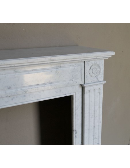 Neoclassical-style fireplace mantel carved in white Carrara marble. This mantelpiece is outstanding for its small and nice size.