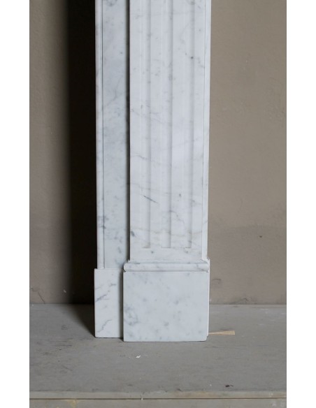 Neoclassical-style fireplace mantel carved in white Carrara marble. This mantelpiece is outstanding for its small and nice size.