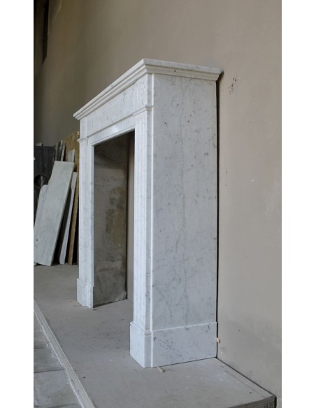 Neoclassical-style fireplace mantel carved in white Carrara marble. This mantelpiece is outstanding for its small and nice size.