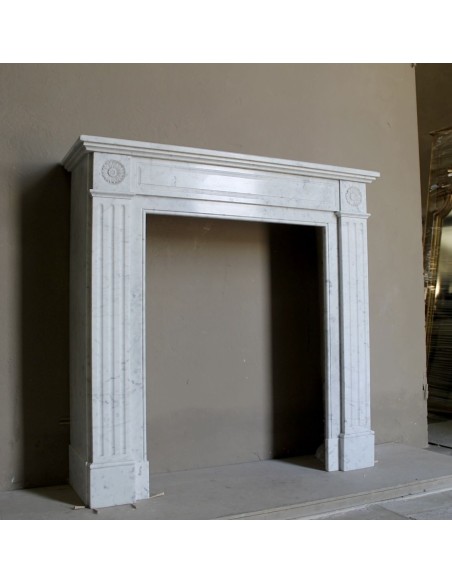 Neoclassical-style fireplace mantel carved in white Carrara marble. This mantelpiece is outstanding for its small and nice size.
