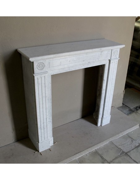 Neoclassical-style fireplace mantel carved in white Carrara marble. This mantelpiece is outstanding for its small and nice size.