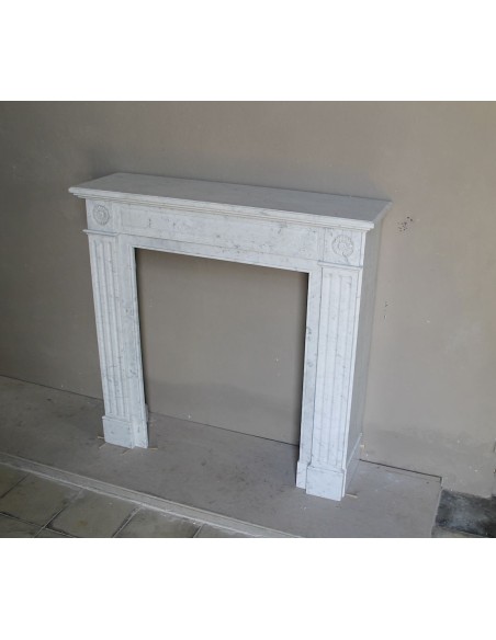 Neoclassical-style fireplace mantel carved in white Carrara marble. This mantelpiece is outstanding for its small and nice size.