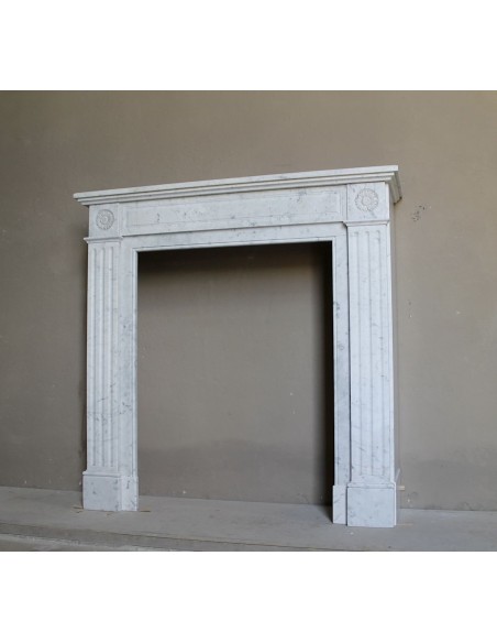 Neoclassical-style fireplace mantel carved in white Carrara marble. This mantelpiece is outstanding for its small and nice size.
