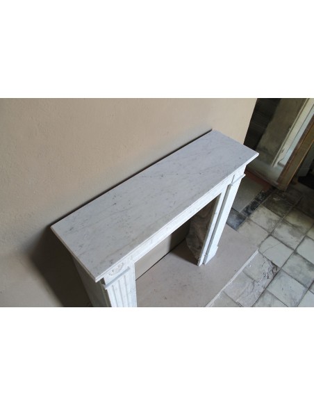 Neoclassical-style fireplace mantel carved in white Carrara marble. This mantelpiece is outstanding for its small and nice size.