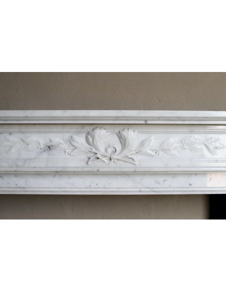 Louis XVI “Olive Branch” fireplace mantel with floral carvings in white marble, mid 20th century, offered at a discounted price.