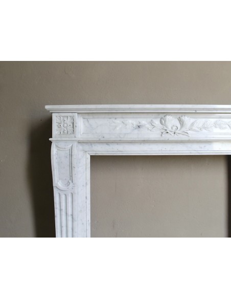 Louis XVI “Olive Branch” fireplace mantel with floral carvings in white marble, mid 20th century, offered at a discounted price.