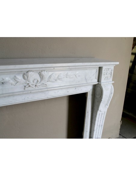 Louis XVI “Olive Branch” fireplace mantel with floral carvings in white marble, mid 20th century, offered at a discounted price.