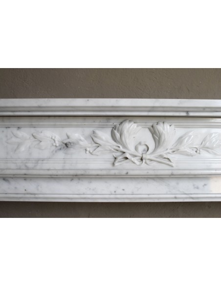 Louis XVI “Olive Branch” fireplace mantel with floral carvings in white marble, mid 20th century, offered at a discounted price.