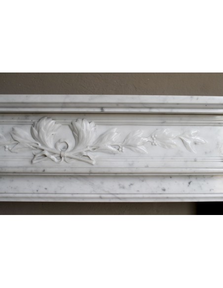 Louis XVI “Olive Branch” fireplace mantel with floral carvings in white marble, mid 20th century, offered at a discounted price.