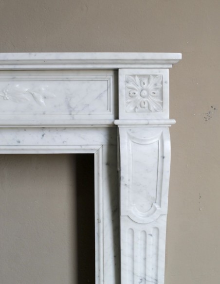 Louis XVI “Olive Branch” fireplace mantel with floral carvings in white marble, mid 20th century, offered at a discounted price.