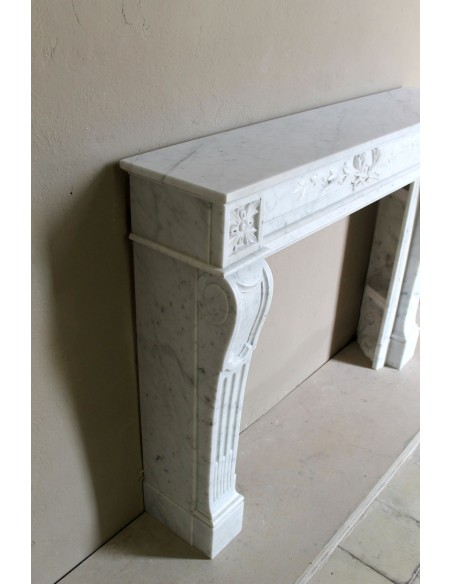 Louis XVI “Olive Branch” fireplace mantel with floral carvings in white marble, mid 20th century, offered at a discounted price.