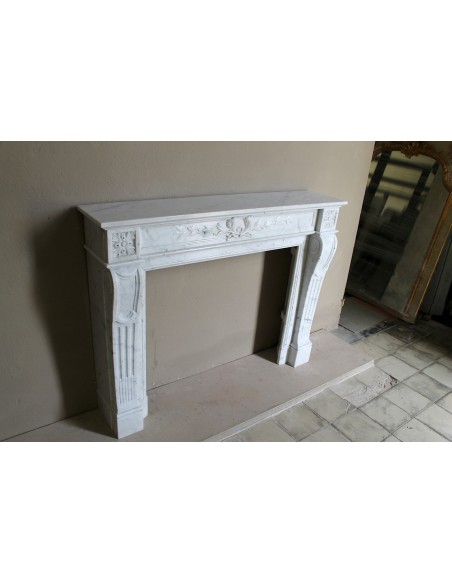 Louis XVI “Olive Branch” fireplace mantel with floral carvings in white marble, mid 20th century, offered at a discounted price.