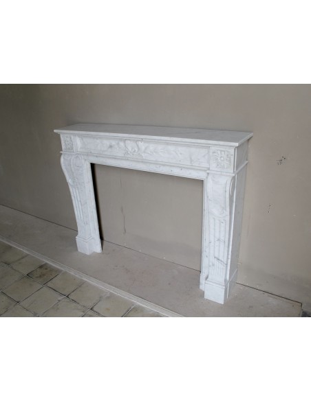 Louis XVI “Olive Branch” fireplace mantel with floral carvings in white marble, mid 20th century, offered at a discounted price.