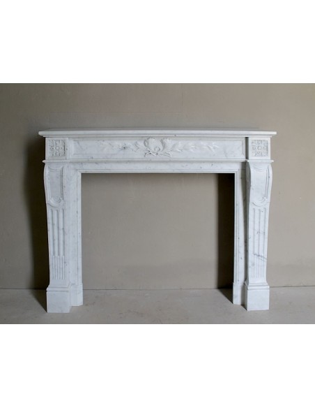 Louis XVI “Olive Branch” fireplace mantel with floral carvings in white marble, mid 20th century, offered at a discounted price.