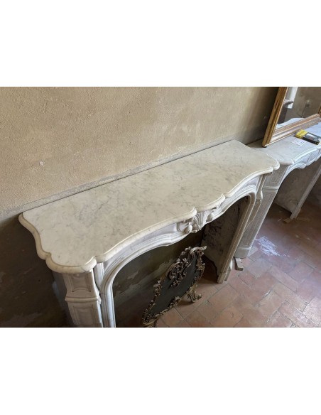 Antique fireplace mantel in white Carrara marble, Louis XV style, carved during the second half of the 19th century.
