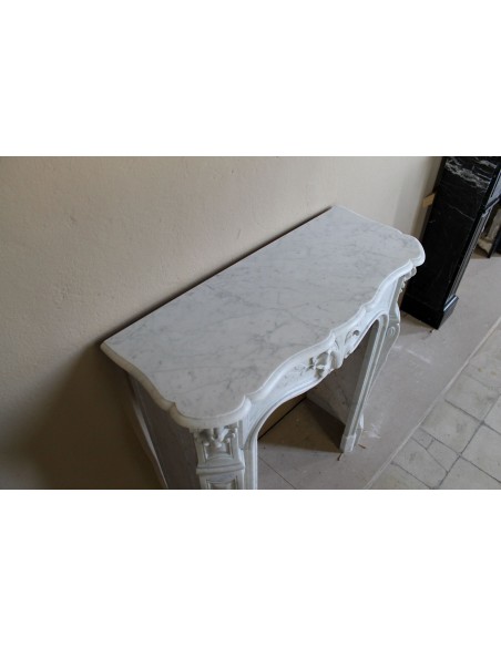 Extremely rare baroque fireplace of very small dimensions and significant decorative carvings in white Carrara marble.