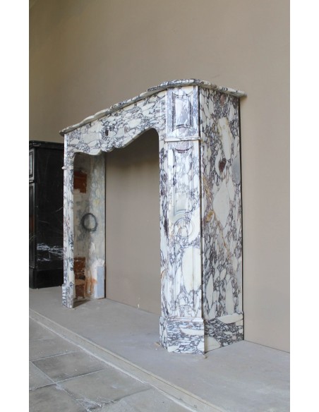 Small antique Baroque fireplace carved in very rare and famous Breccia Violetta marble, an elegant and colorful marble.