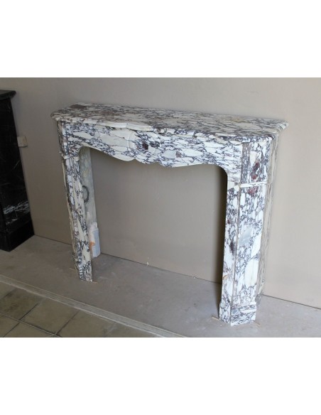 Small antique Baroque fireplace carved in very rare and famous Breccia Violetta marble, an elegant and colorful marble.