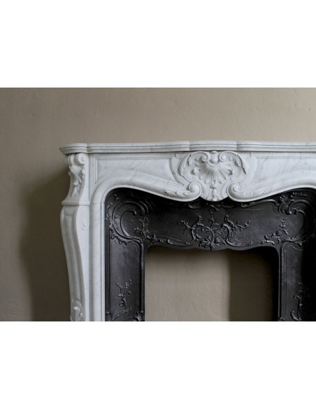 Floral Louis XV fireplace mantel carved in white marble, with shell decorations, complete with its original cast iron insert.