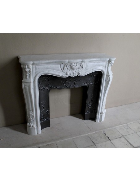 Floral Louis XV fireplace mantel carved in white marble, with shell decorations, complete with its original cast iron insert.