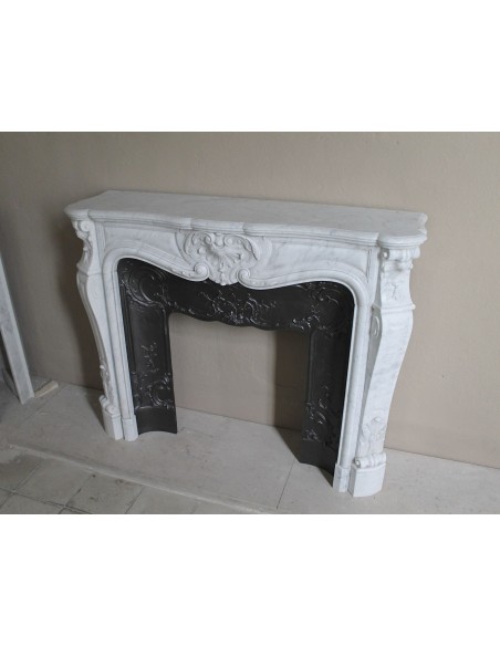 Floral Louis XV fireplace mantel carved in white marble, with shell decorations, complete with its original cast iron insert.