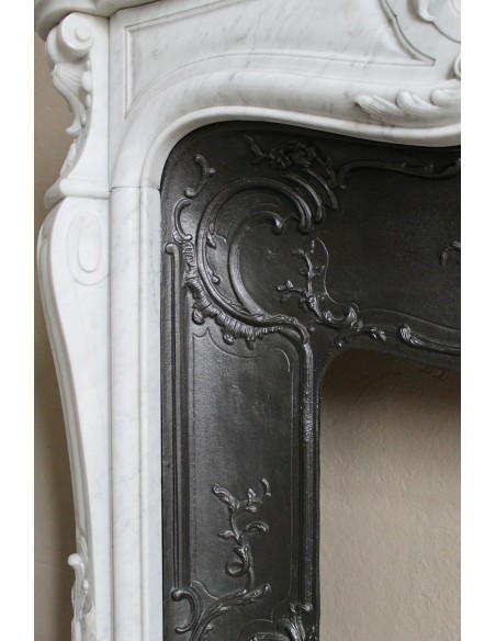 Floral Louis XV fireplace mantel carved in white marble, with shell decorations, complete with its original cast iron insert.