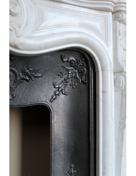 Baroque fireplace mantel in White Carrara marble with floral motifs, complete with decorative cast iron insert.