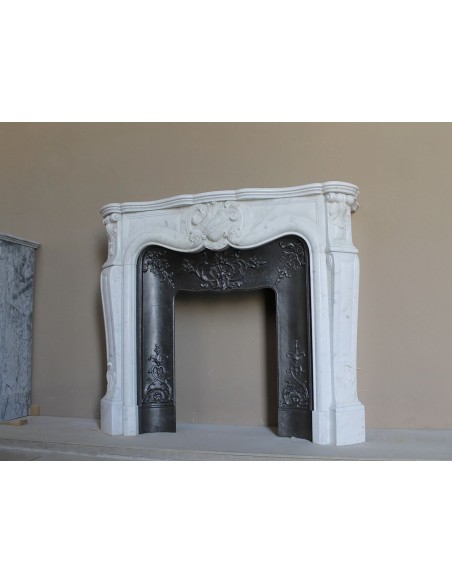 Baroque fireplace mantel in White Carrara marble with floral motifs, complete with decorative cast iron insert.