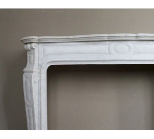 Genuine "Pompadour" fireplace mantel in pure white Carrara marble, featuring decorated bronze side openings. 2