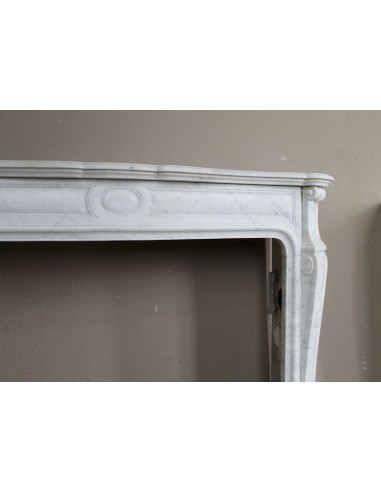 Genuine "Pompadour" fireplace mantel in pure white Carrara marble, featuring decorated bronze side openings.