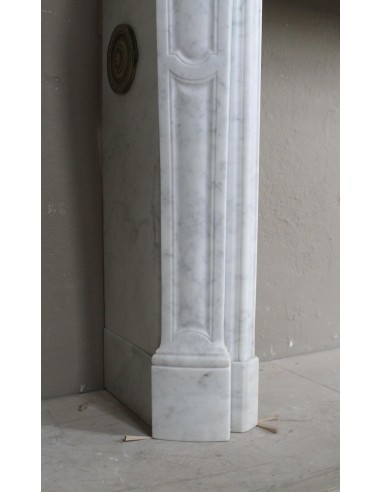 Genuine "Pompadour" fireplace mantel in pure white Carrara marble, featuring decorated bronze side openings.