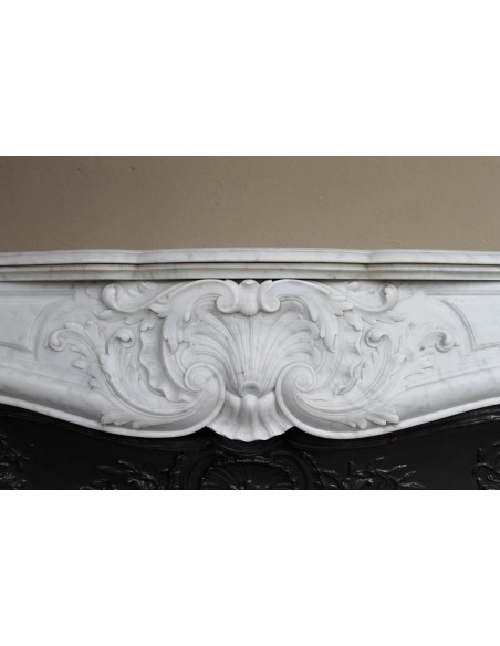 Antique Louis XV fireplace mantel in white marble with elegant floral decorations, with its original artistic cast-iron insert