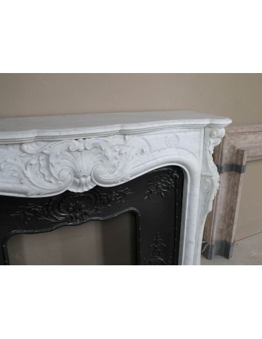 Antique Louis XV fireplace mantel in white marble with elegant floral decorations, with its original artistic cast-iron insert
