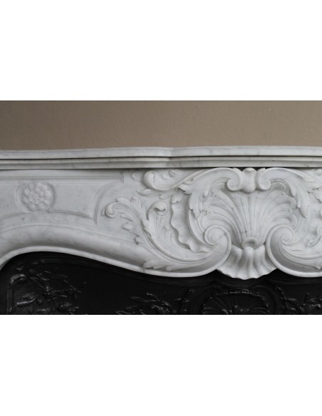 Antique Louis XV fireplace mantel in white marble with elegant floral decorations, with its original artistic cast-iron insert
