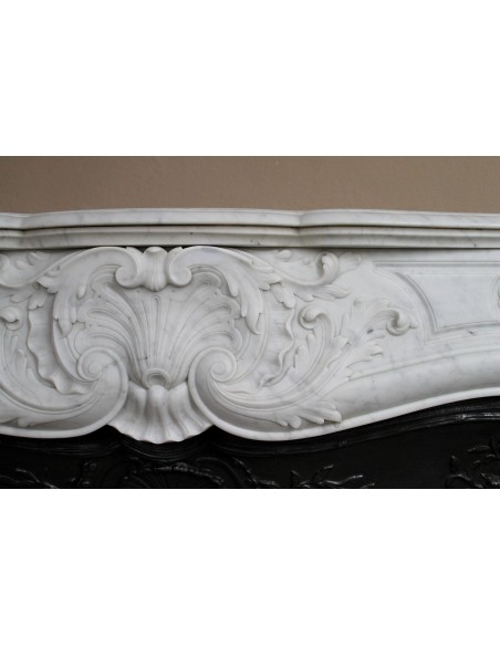Antique Louis XV fireplace mantel in white marble with elegant floral decorations, with its original artistic cast-iron insert