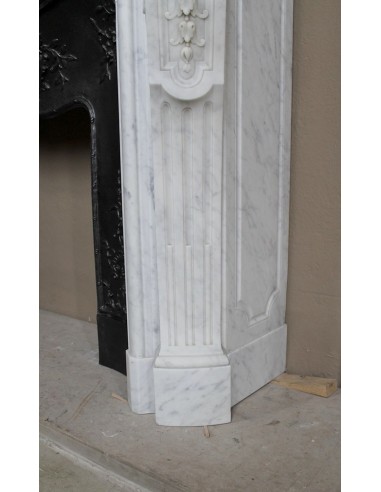 Antique Louis XV fireplace mantel in white marble with elegant floral decorations, with its original artistic cast-iron insert