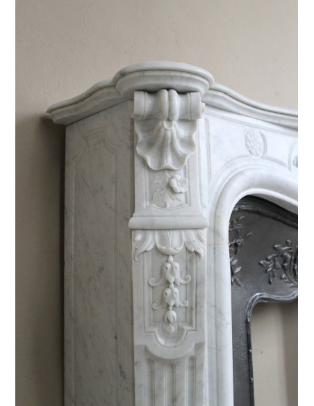 Antique Louis XV fireplace mantel in white marble with elegant floral decorations, with its original artistic cast-iron insert