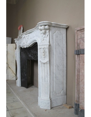 Antique Louis XV fireplace mantel in white marble with elegant floral decorations, with its original artistic cast-iron insert