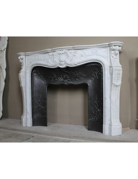 Antique Louis XV fireplace mantel in white marble with elegant floral decorations, with its original artistic cast-iron insert