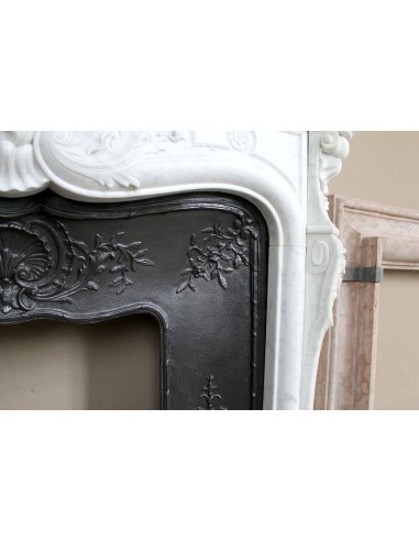 Antique Louis XV fireplace mantel in white marble with elegant floral decorations, with its original artistic cast-iron insert