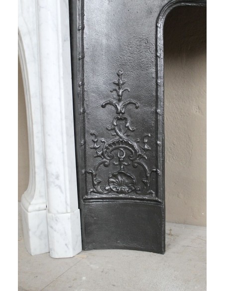 Antique Louis XV fireplace mantel in white marble with elegant floral decorations, with its original artistic cast-iron insert