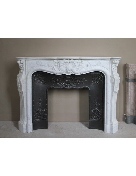 Antique Louis XV fireplace mantel in white marble with elegant floral decorations, with its original artistic cast-iron insert