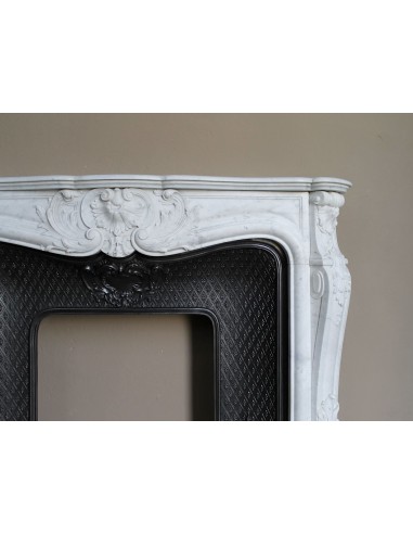 Louis XV “Moustache” fire surround in “Pure White" Carrara marble, complete with cast iron insert featuring floral decorations.