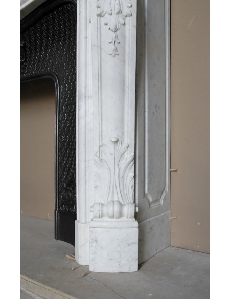Louis XV “Moustache” fire surround in “Pure White" Carrara marble, complete with cast iron insert featuring floral decorations.