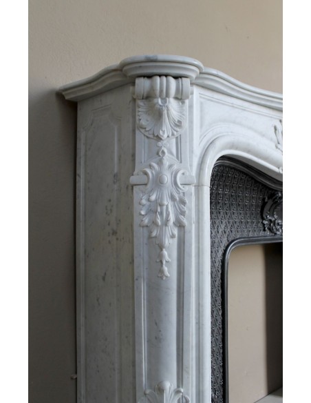 Louis XV “Moustache” fire surround in “Pure White" Carrara marble, complete with cast iron insert featuring floral decorations.