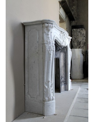 Louis XV “Moustache” fire surround in “Pure White" Carrara marble, complete with cast iron insert featuring floral decorations.