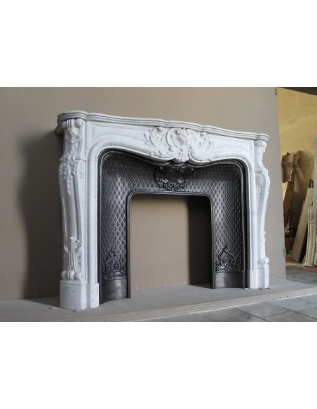Louis XV “Moustache” fire surround in “Pure White" Carrara marble, complete with cast iron insert featuring floral decorations.