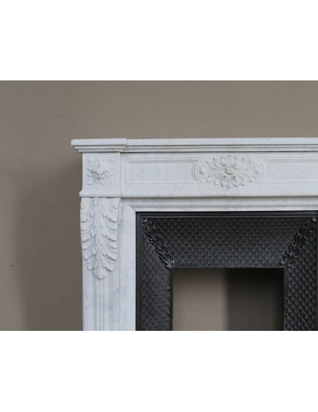 Neoclassical "Trois Fleurs" fireplace mantel in white marble with cast iron insert, small size and rich decorative detailing.
