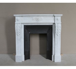 Neoclassical "Trois Fleurs" fireplace mantel in white marble with cast iron insert, small size and rich decorative detailing.